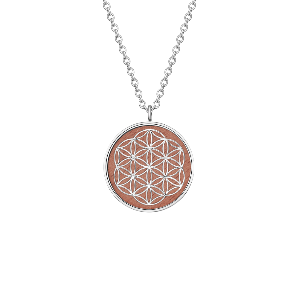 Silberne Halskette mit rundem Anhänger, verziert mit dem Symbol der Blume des Lebens auf Holz Hintergrund.