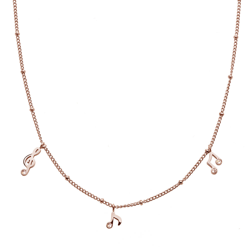 Roségoldfarbene Halskette mit kleinen Musiknoten- und Violinschlüssel-Anhängern, verziert mit funkelnden Ziersteinen.