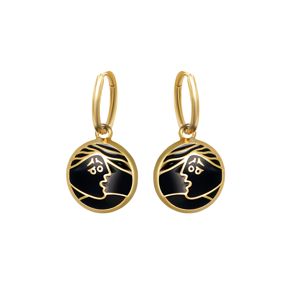 Modische Creolen mit rundem Anhänger in goldfarbener Fassung – schwarzes Emaille-Design mit stilisiertem Gesichtsmotiv in Goldlinien.