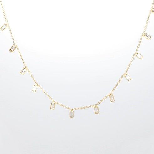Halskette mit rechteckigen, klaren Kristallanhängern an einer feinen goldfarbenen Kette.