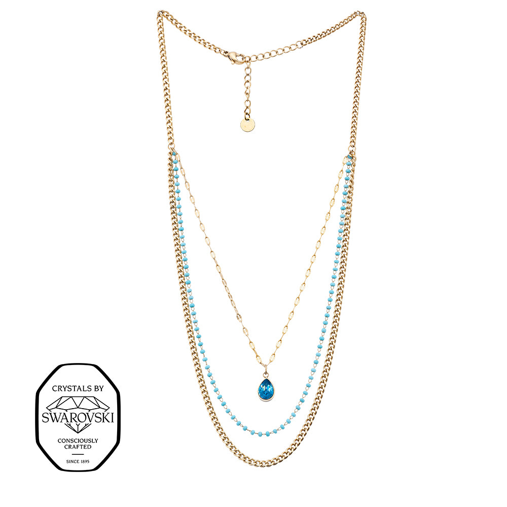 Goldene Layer-Halskette mit drei Reihen, blauen Perlen und einem tropfenförmigen Swarovski® Kristall-Anhänger.