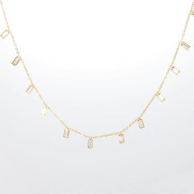 Halskette mit rechteckigen, klaren Kristallanhängern an einer feinen goldfarbenen Kette.